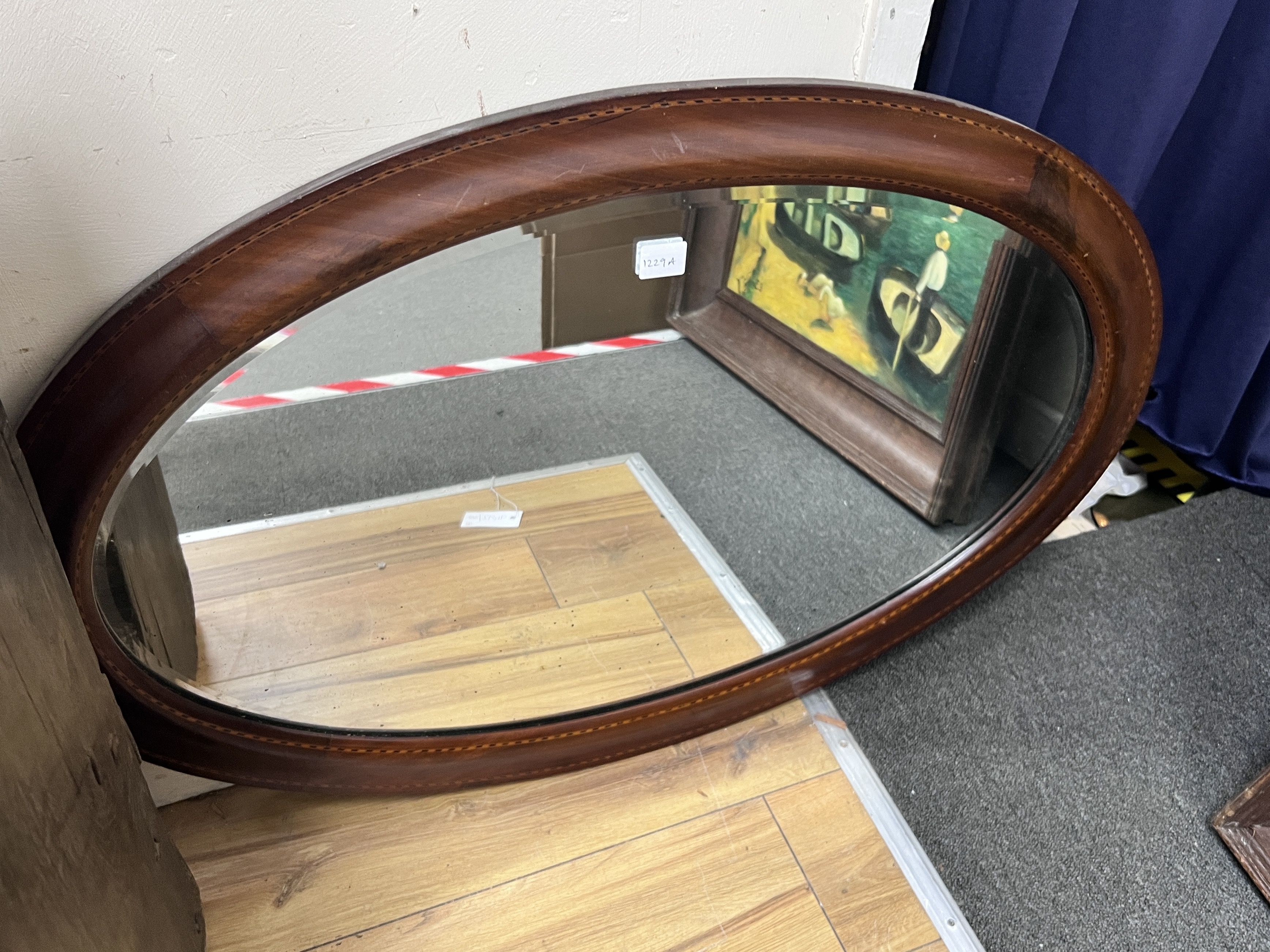 An Edwardian banded mahogany oval wall mirror, width 86cm, height 58cm